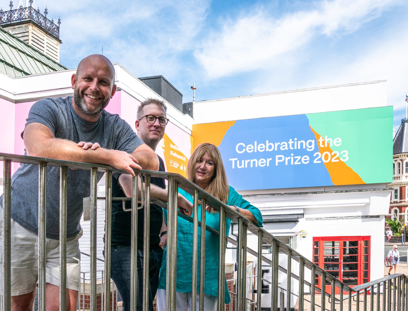 Identity team stand in front of sign celebrating the Turner Prize